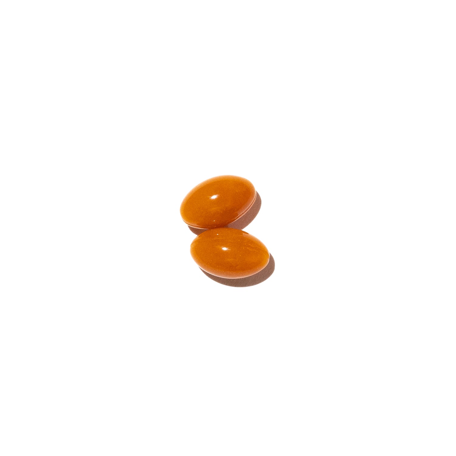 Two orange recovery-pills on a white background.